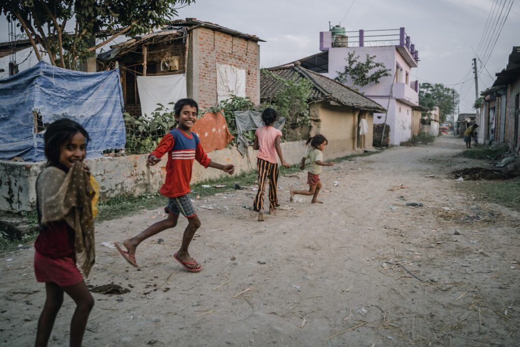 Children running joyfully in a village supported by SAF International, showcasing the impact of humanitarian aid