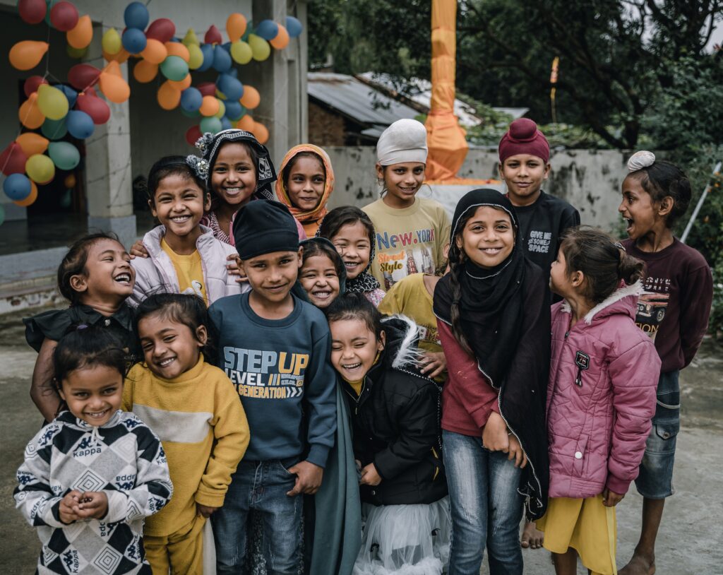 Group of smiling Sikh children supported by SAF International, showcasing the positive impact of community aid programs and the power of programs like legacy giving